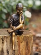 Bronzeskulptur Sitzender Junge auf Baumstamm 
