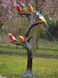 Bronzeskulptur Papageien auf Baumfragment im Garten 