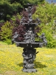 Bronzeskulptur Brunnen mit Engel beschichtet mit einer grünen Patina stehend im Garten 
