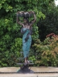 Bronzeskulptur Frau als Brunnen im Garten mit grün brauner Patina