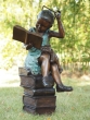 Bronzeskulptur Mädchen sitzend auf Büchern mit einer kleinen Katze auf dem Knie 