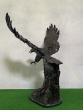 Bronzeskulptur Steinadler fliegend auf Baumstamm von hinten