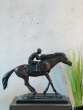 Bronzeskulptur Jockey mit einer braunen Patina von der Seite