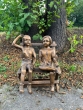 Bronzeskulptur Erik und Sophie auf einer Bank im Wald mit brauner Patina 