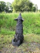 Bronzeskulptur Heulender Sitzender Wolf von hinten in einem Garten