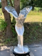 Bronzeskulptur Spirit of Ecstasy mit silbernen Patina in einem Garten