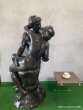 Der Kuss von Auguste Rodin von der Seite aus Bronze neben einem Tisch