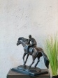 Bronzeskulptur Jockey mit brauner Patina und auf einem Marmorsockel von hinten
