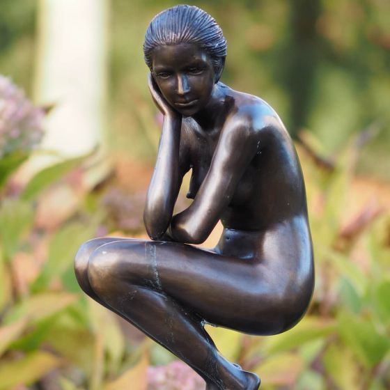 Bronzeskulptur Frau hockend auf Säule