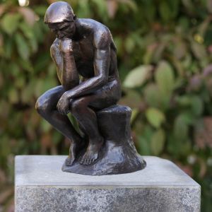 Bronzeskulptur Der Denker von A. Rodin in brauner Patina auf Säule im Garten 