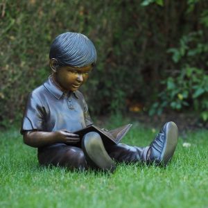 Ansicht der Bronzefigur "Junge Tommi liest Buch"