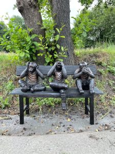 Bronzeskulptur Drei Affen auf einer Bank im Wald