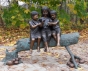 Bronzeskulptur Drei Mädchen sitzend auf einem Baumstamm mit braun grüner Patina 