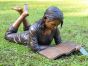 Bronzeskulptur Paula liegend mit Ihrem Buch im Garten 