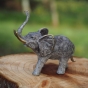 Bronzeskulptur Stehender Elefant mit grauer Patina auf einem Baumstamm
