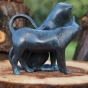 Bronzeskulptur Schmuse Katzen mit grüner Patina auf einem Baumstamm im Garten von hinten