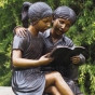 Bronzefigur Mädchen und Junge mit ihrem Buch 