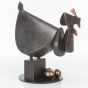 Seitenansicht der Bronzeskulptur "Die schwarze Henne legt abends ihre Eier"