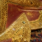 Gewand vom Buddha aus Holz in rot und gold mit Spiegelchen