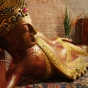 Buddhafigur liegend von der Seite in rot und gold