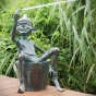 Frosch speit Wasser und sitzt auf der Hand eines Gnom aus Bronze