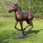 Bronzefigur "Laufendes Fohlen" auf einer Wiese