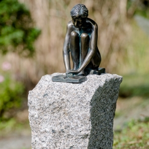 Bronzeskulptur "Sitzendes Mädchen Iris" auf Granitsockel von vorne