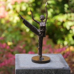 Bronzeskulptur Junge Tänzerin mit brauner Patina auf einer Säule im Garten 