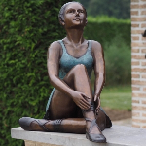 Bronzeskulptur Sitzende Ballerina mit grün brauner Patina im Garten 