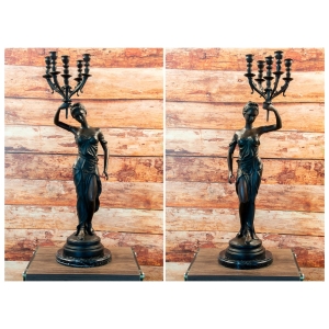 Antike Kerzenständer aus Bronze zweier Frauen auf Marmorsockel vor Holzwand