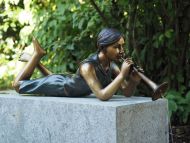 bronzefigur Mädchen liegend mit flöte
