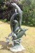 Bronzeskulptur vier Delfine als Wasserspeier mit grüner Patina im Garten 