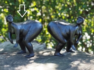 Zwei dicke Frauen als Bronzefiguren auf Baumstamm
