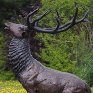 Bronzeskulptur Stehender Hirsch mit brauner Patina im Garten 