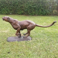 Bronzeskulptur "Laufender Gepard" auf Sockel mit einer braunen Patina