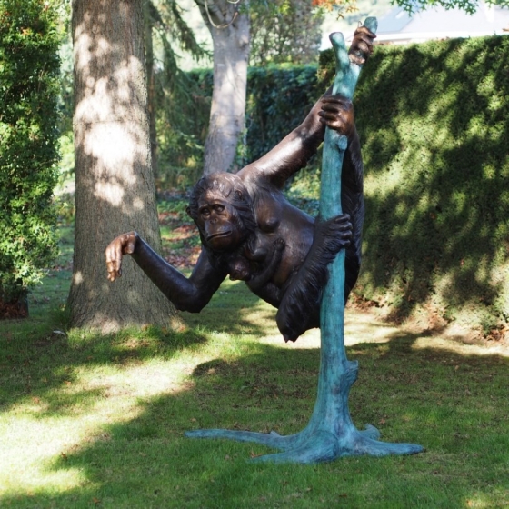 Bronzeskulptur "Orang-Utan Weibchen mit Jungtier" auf Baumstamm