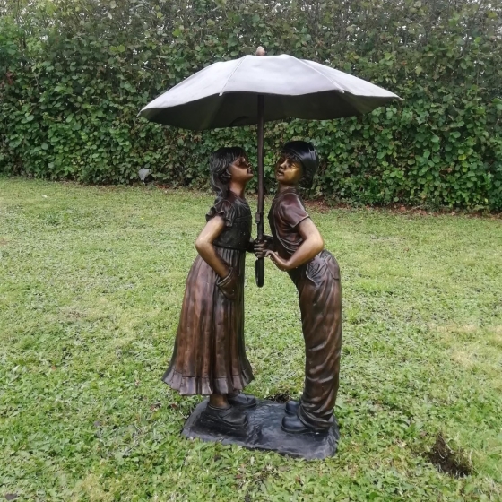 Bronzeskulptur "Ellie und Max" als Wasserspeier unter einem  Regenschirm 