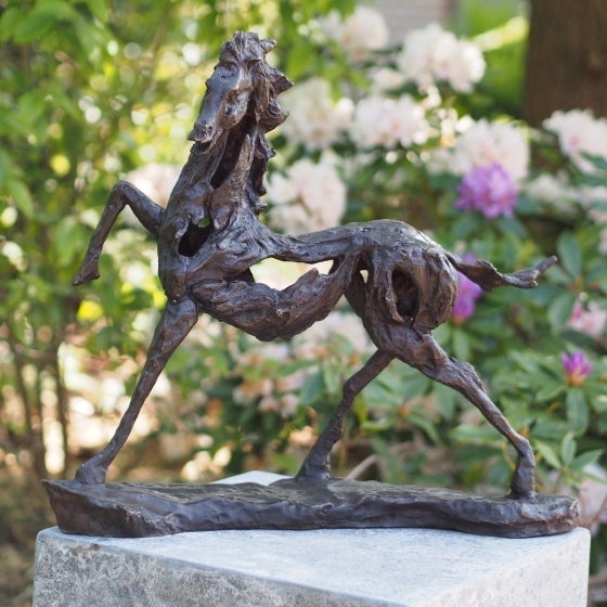 Pferdeskulptur aus Bronze auf Sockel im Garten
