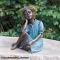 Bronzeskulptur Sitzendes Mädchen auf Säule im Garten 
