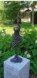 Bronzeskulptur Stehende Frau mit brauner Patina auf einem Sockel im Garten 