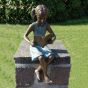Bronzeskulptur Mädchen mit Buch sitzend auf einer Säule