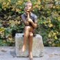 Bronzeskulptur Sitzendes Mädchen mit Hand am Kinn auf einem Stein 