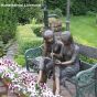 Bronzeskulptur Sitzende Mädchen auf Gartenbank mit Buch und Stift 