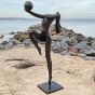 Moderne Bronzefigur auf einem Sockel am Strand