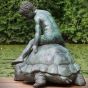Gartenfigur Junge auf Schildkröte