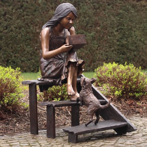 Bronzeskulptur Sitzendes Mädchen auf Treppe mit Ihrem Hund im Garten