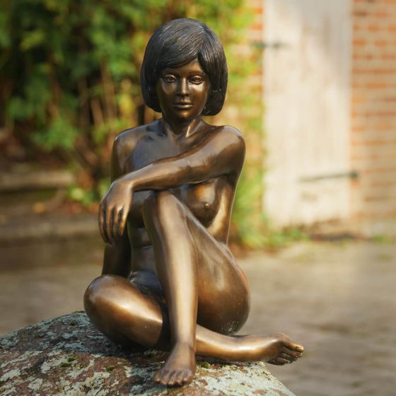 Bronzeskulptur Natürliche Frau sitzend auf einem Stein