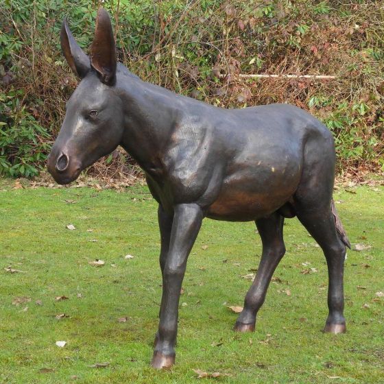 Bronzeskulptur Stehender Esel mit brauner Patina auf einer Wiese 