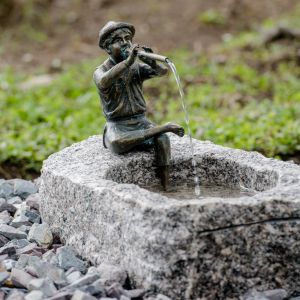 Bronzeskulptur "Flötenspieler Finn" als Wasserspeier auf einem Stein