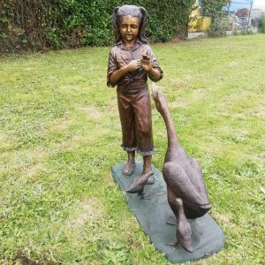 Bronzeskulptur "Johanna mit Gänsefamilie" auf einer Wiese